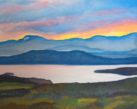 Sunset over mountains with a serene lake in the foreground and colorful sky.