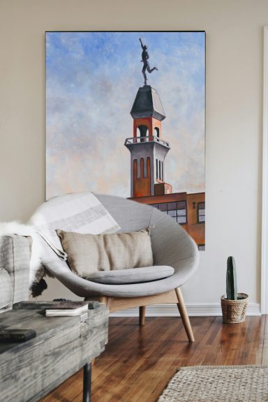 Modern indoor space featuring a curved chair, a large clock tower painting, and a small cactus.