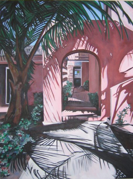 Pink building archway framed by palm trees and shadowed walkway.