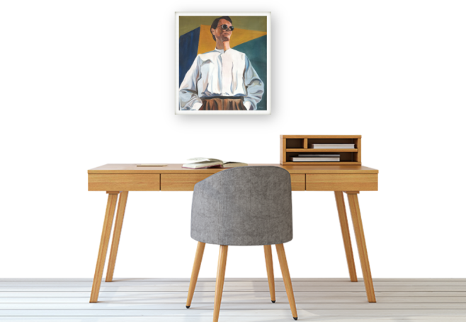 A modern desk with a gray chair and a framed portrait on the wall above.