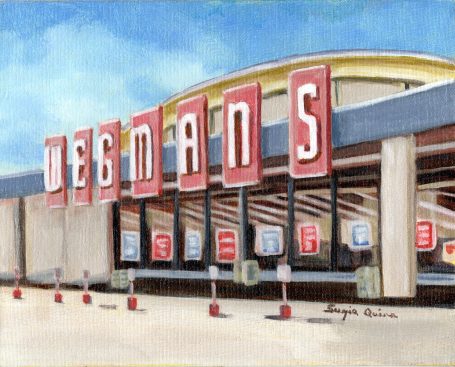 Exterior view of a Wegmans grocery store with large signs and a clear blue sky.